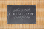Personalised rectangular slate serving board with engraved wording and a selection of cheese and accompaniments.