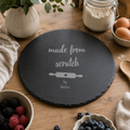 Personalised round slate cake plate engraved with a “Made From Scratch” baking design and name.