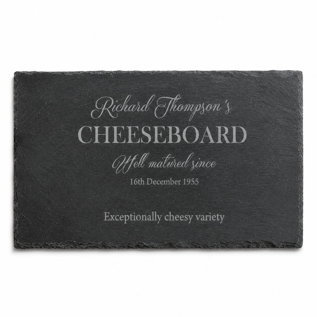 Personalised slate cheeseboard in a cosy lifestyle setting, surrounded by wine, crackers, olives and cheese.