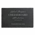Personalised slate cheeseboard in a cosy lifestyle setting, surrounded by wine, crackers, olives and cheese.