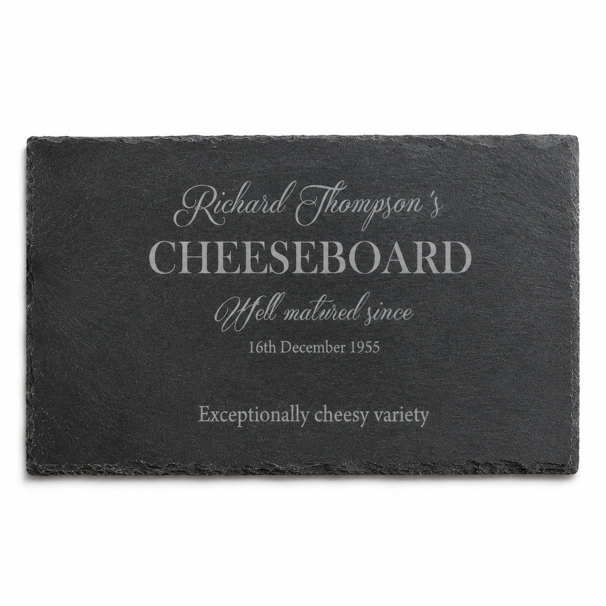 Personalised slate cheeseboard in a cosy lifestyle setting, surrounded by wine, crackers, olives and cheese.