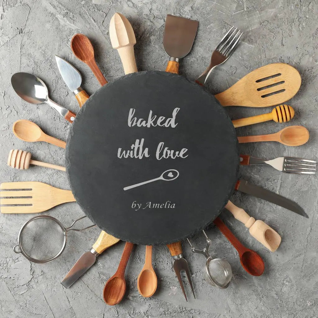 Personalised slate serving plate styled with traditional baking ingredients on a wooden worktop.