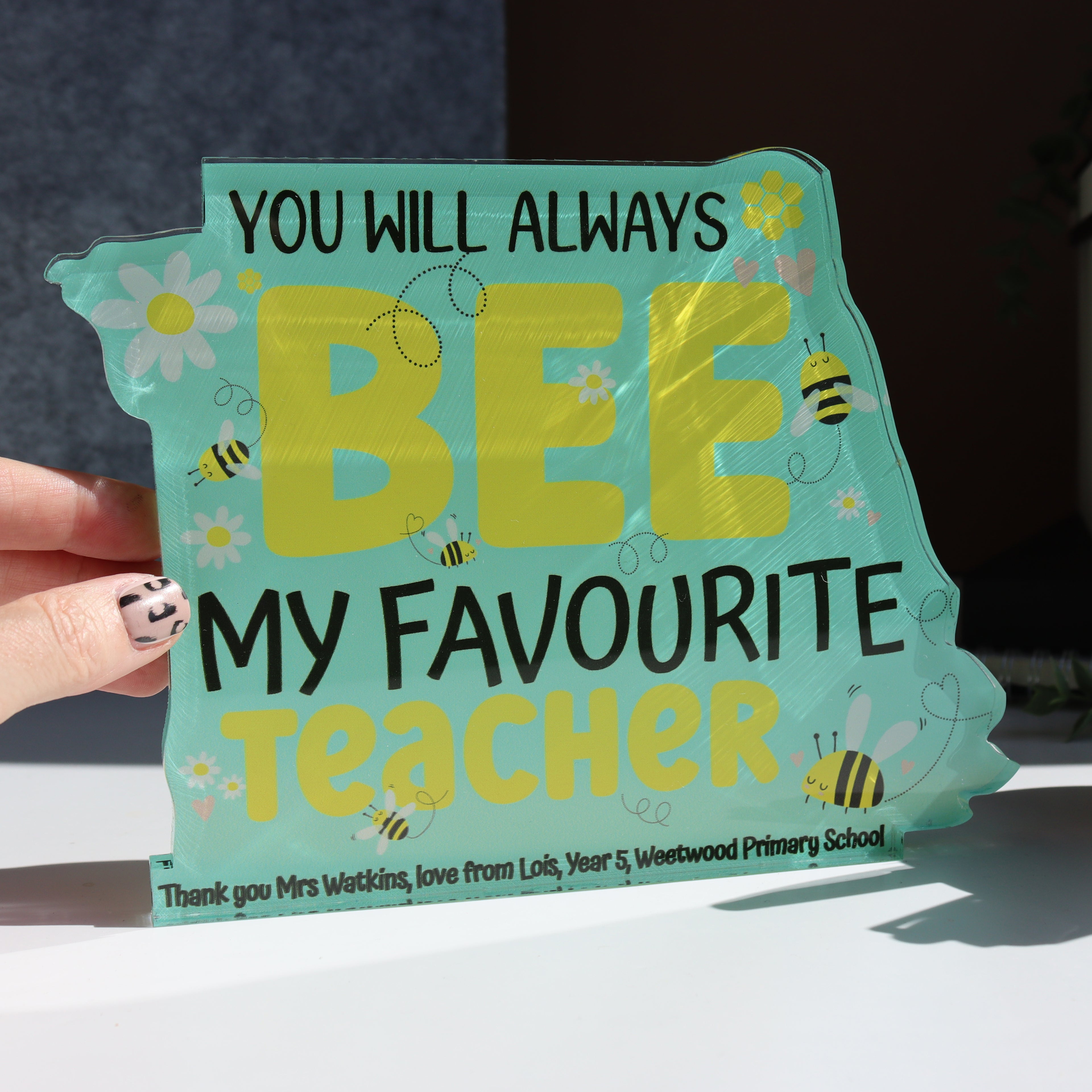 Personalised teacher desk stand with turquoise BEE design and custom message.