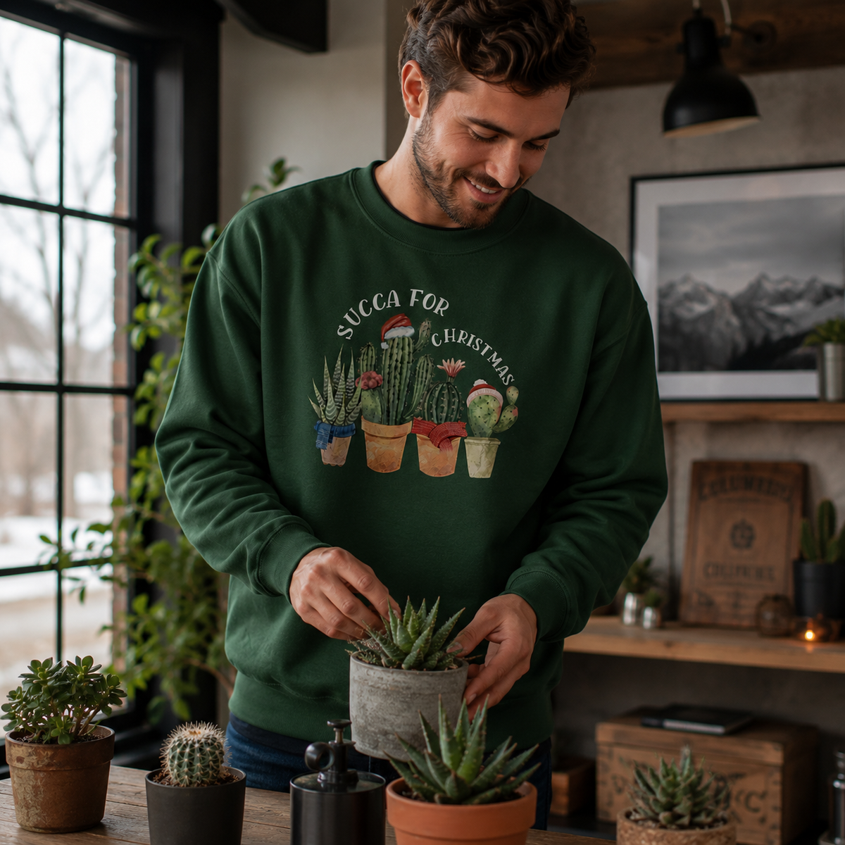 Man tending houseplants, wearing a green Succa For Christmas succulent jumper.