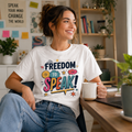 Woman wearing a white Freedom To Speak t-shirt, holding a mug at a desk with a bookshelf and plants.