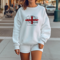 Woman wearing a white England football sweatshirt with lioness and red cross flag design