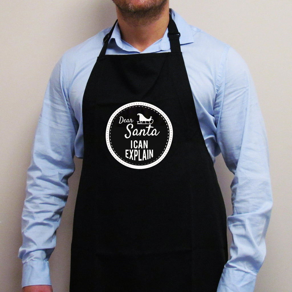 'Dear Santa I Can Explain' Christmas apron in black with a white sleigh badge slogan