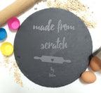 Engraved slate cake plate with “Made From Scratch” design, surrounded by traditional baking essentials.