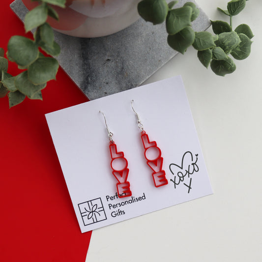 Valentine LOVE earrings shown displayed on a backing card close up