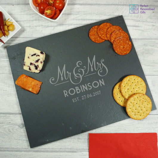 Rectangular slate serving board personalised with a couple’s married name, ideal as a wedding gift.