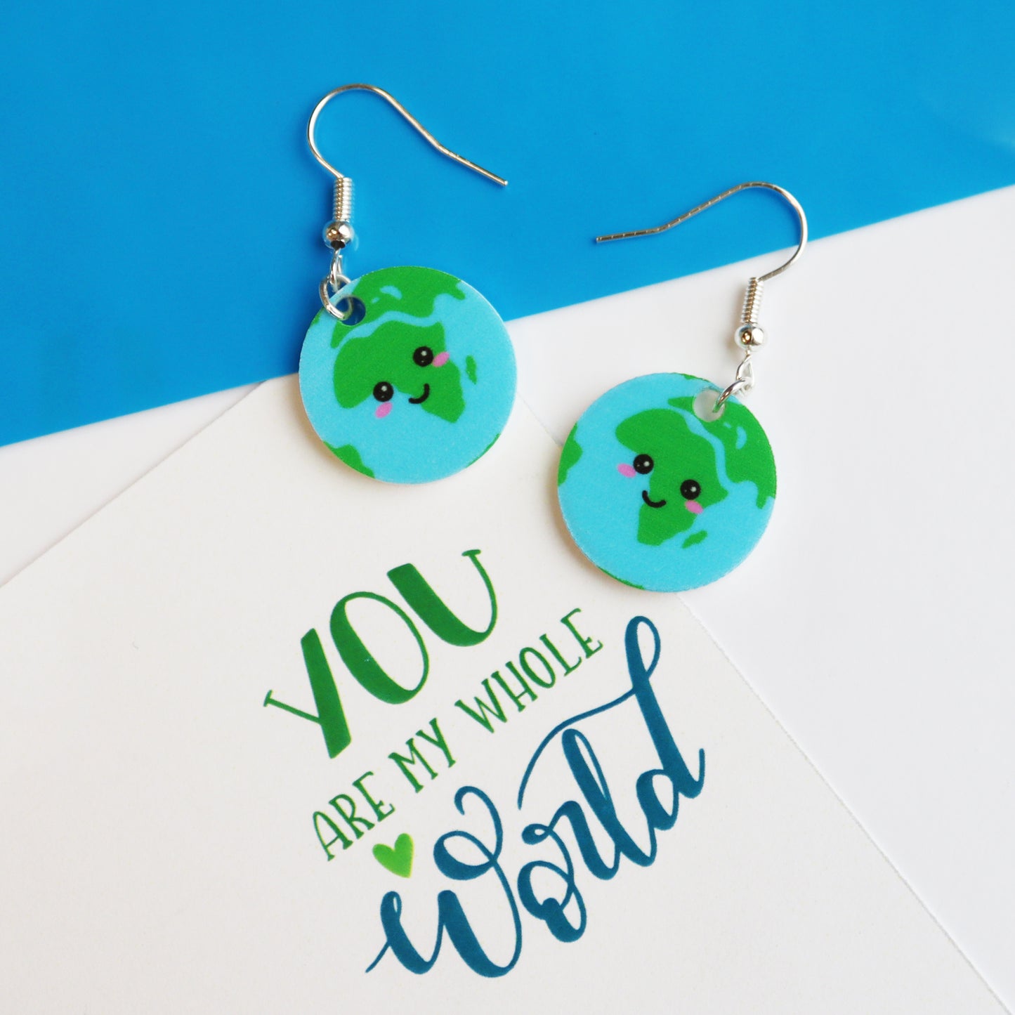 You are my whole world fun kawaii based earth earrings shown in a pair on a mixed media background