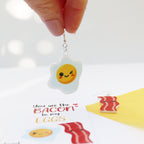 acrylic bacon to my egg acrylic printed earrrings valentine's day earrings funny valentines earrings shown egg being held