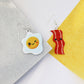 bacon to my eggs earrings shown on a piece of marble