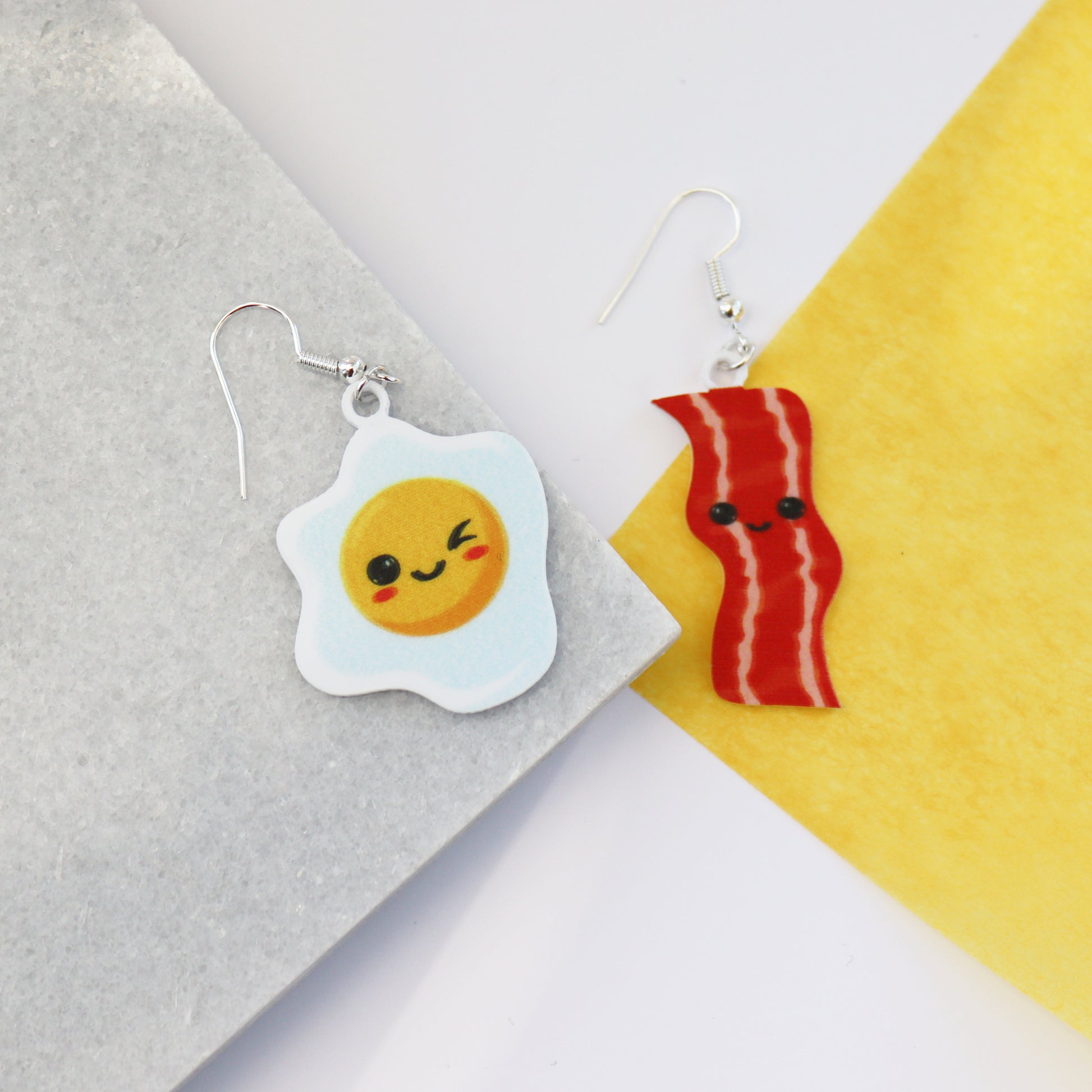 bacon to my eggs earrings shown on a piece of marble