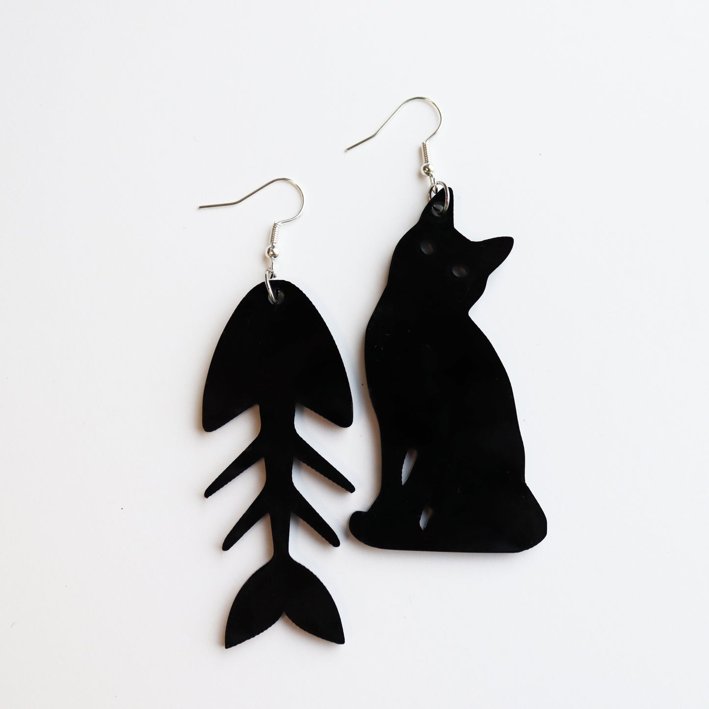 black cat and fish bone mismatches earrings cut from black acrylic with the bone earring on white background