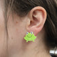 close up of cute you are toadally awesome frog acrylic earrings worn in ear for size reference