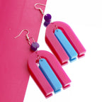 close up of geometric earrings statement modern acrylic earrings on a mirror sheet