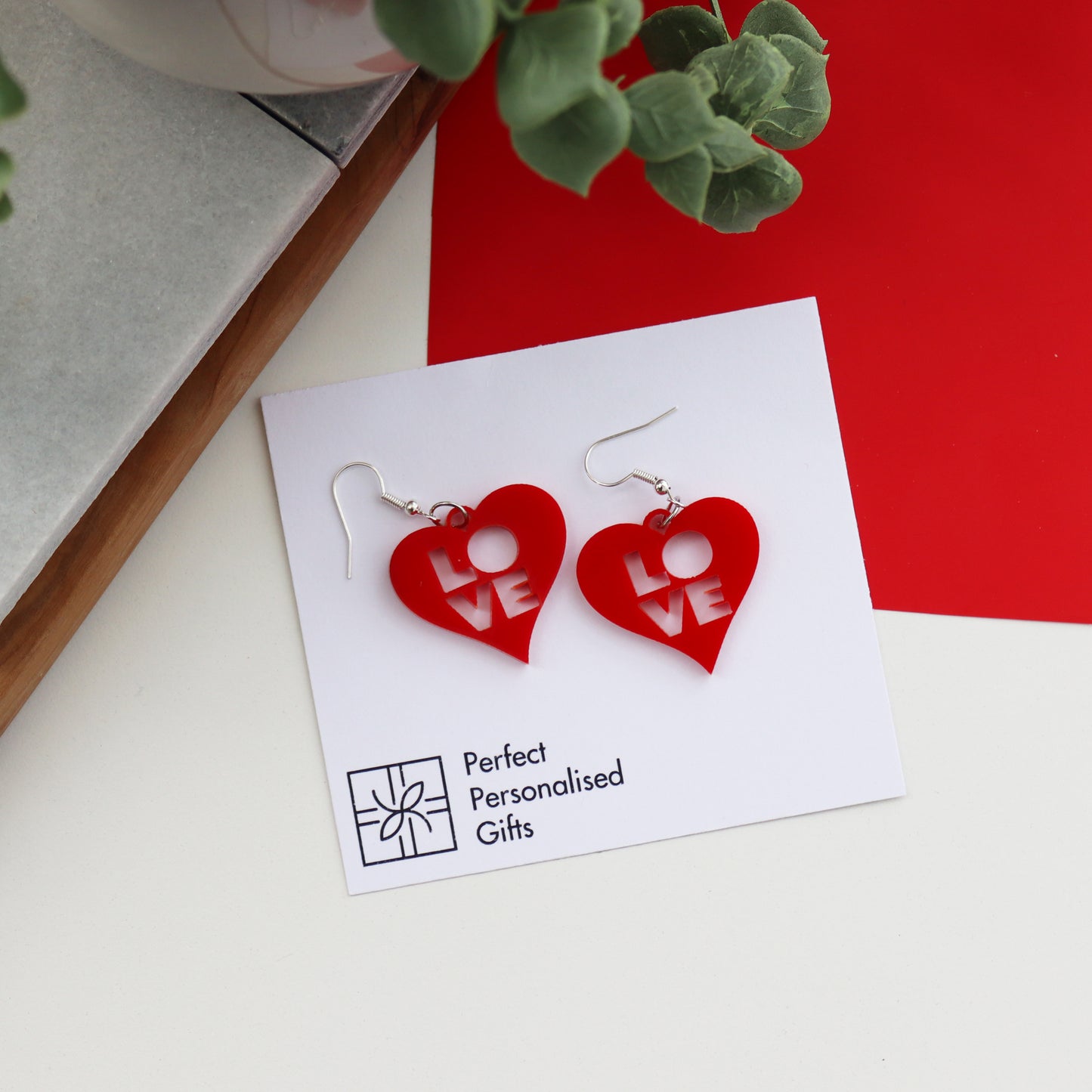 red laser cut acrylic heart earrings with love cut out from the centre