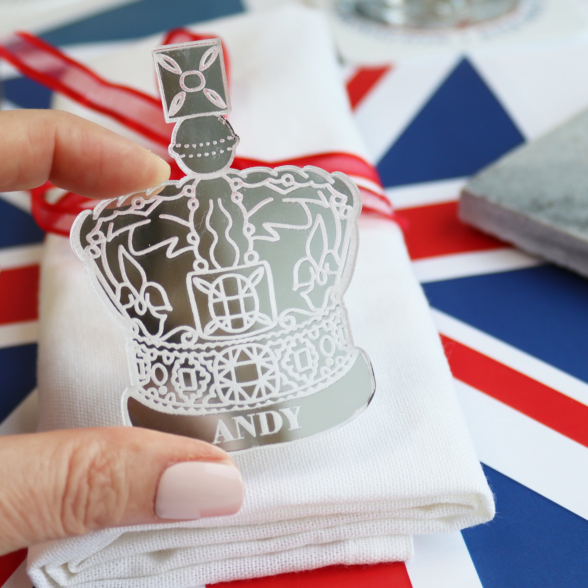 crown place setting held in fingers silver acrylic personalised table setting