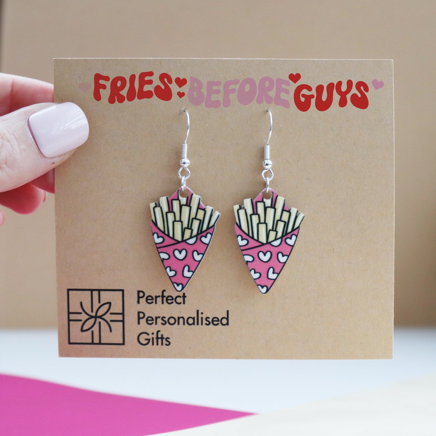 fries before guys earrings cut from acrylic and printed with a bag of chips the card is being held by a hand to show size reference