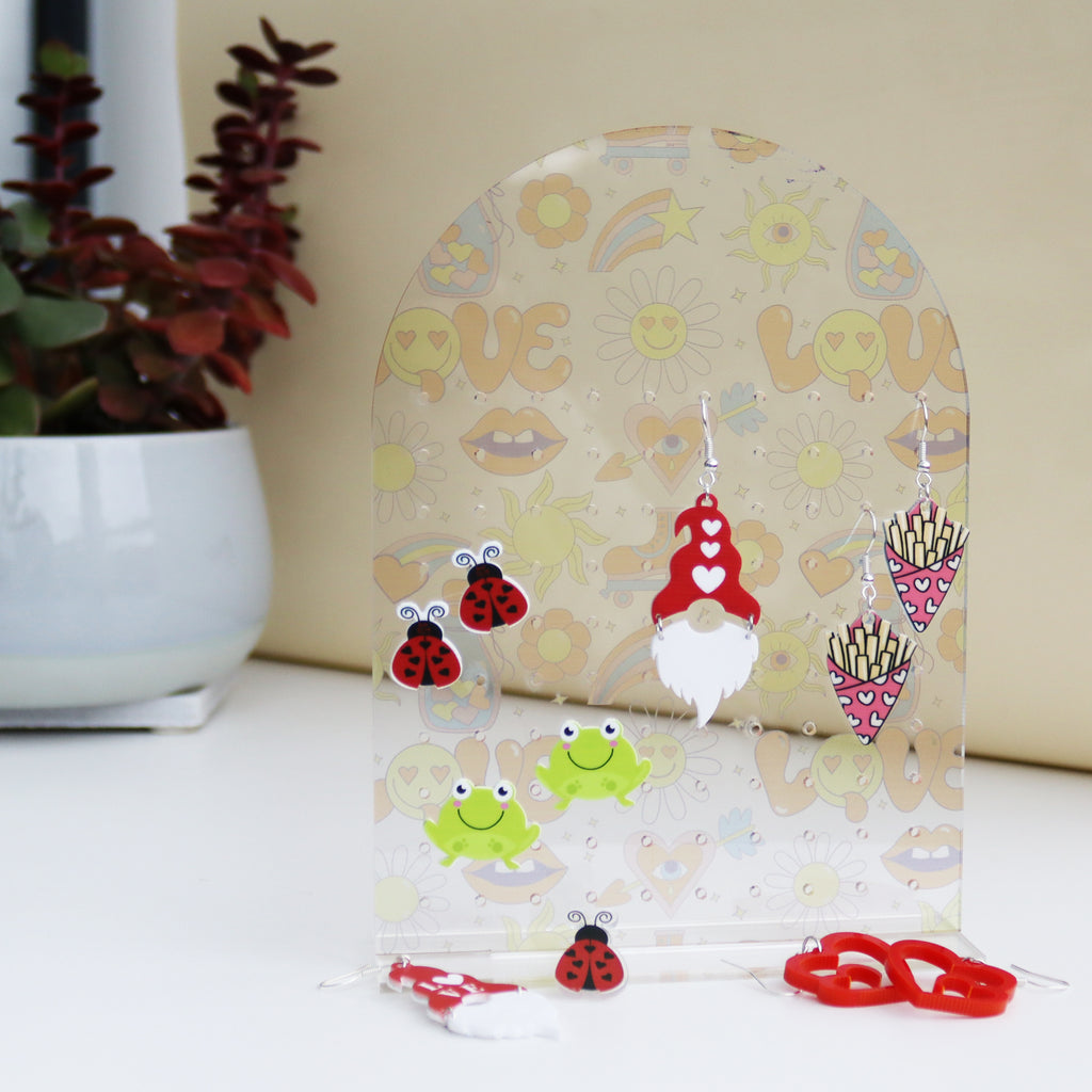funky 70s style LOVE print with sunflowers on an acrylic earrings holder which can hold stud and hook earrings