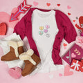 White t-shirt with pastel love heart sweets design, one reading 'Nope'