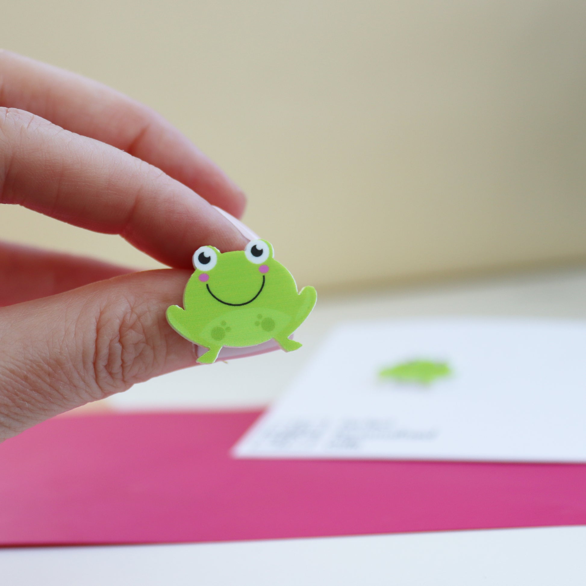 hand holding stud frog acrylic earring for size reference
