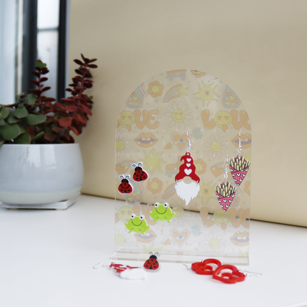 front view of acrylic earring holder with soft funky love print