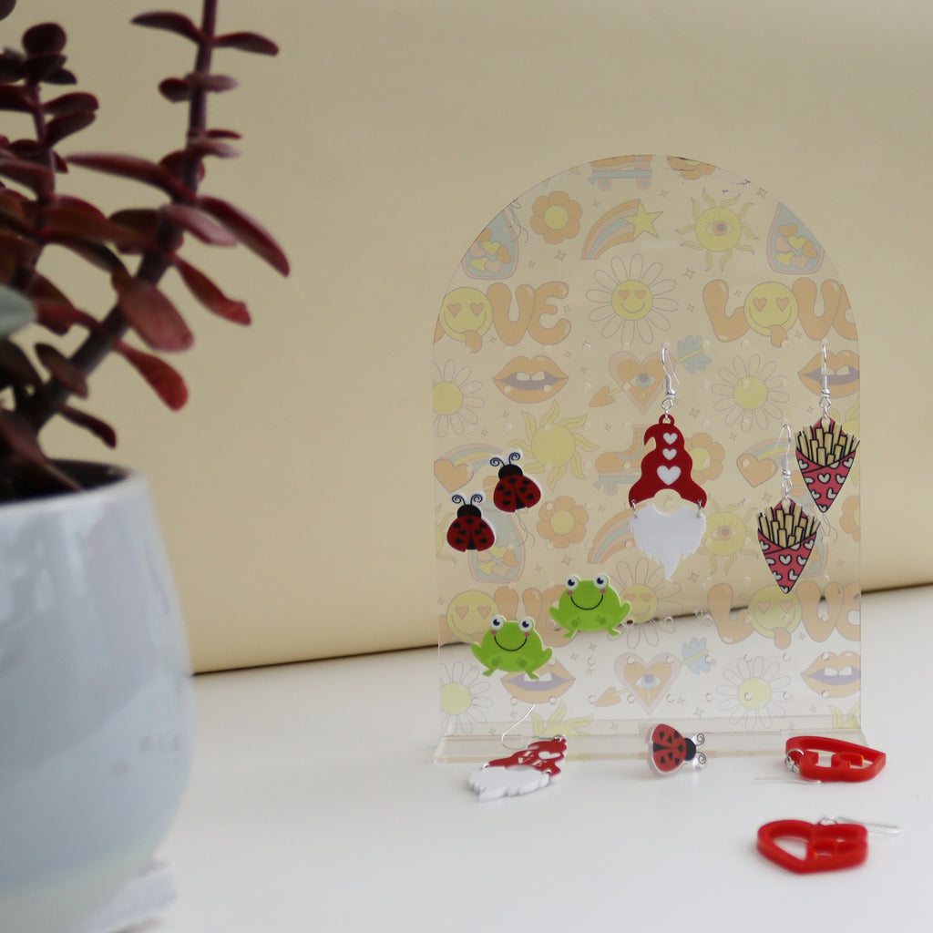 side on view of acrylic earring holder with love funky print