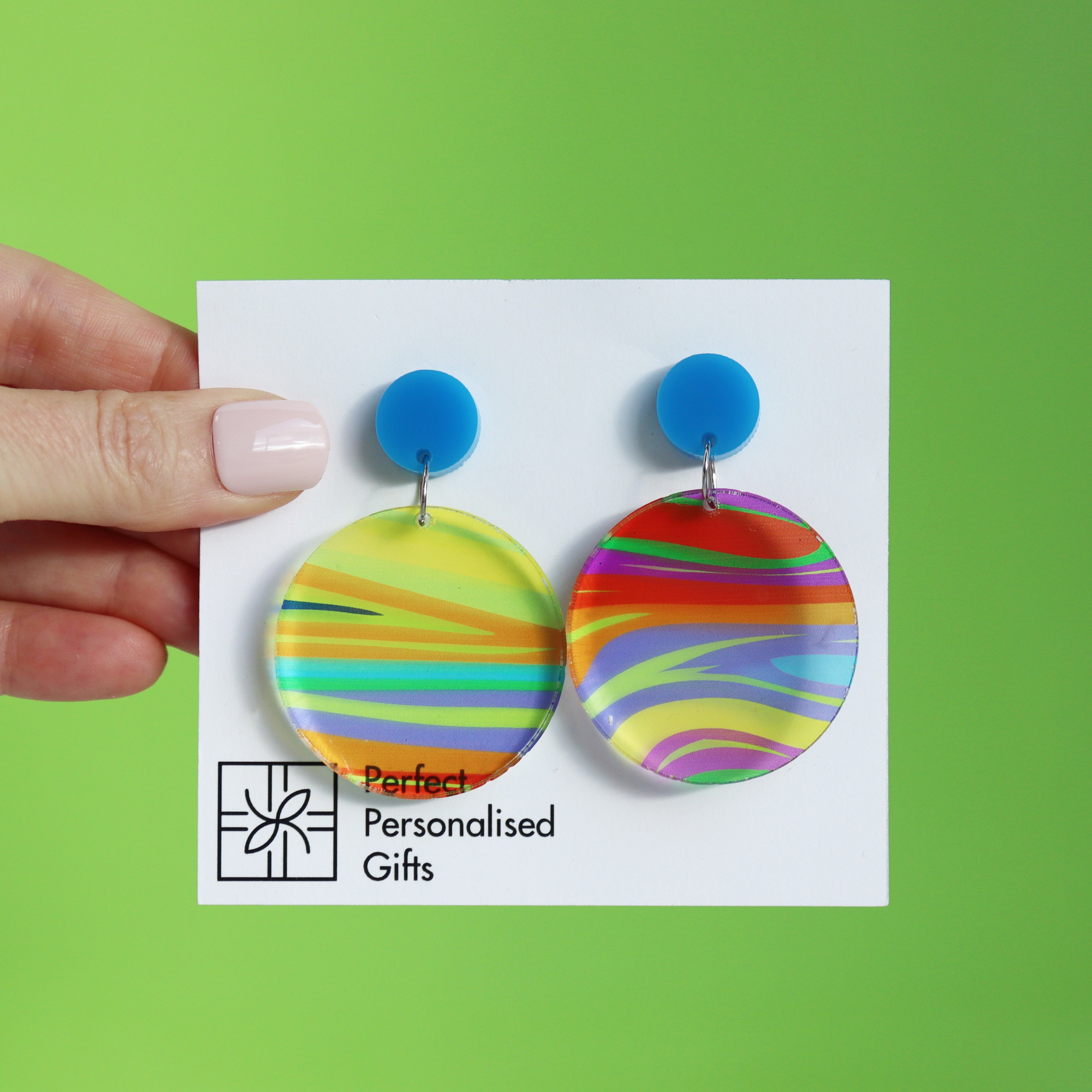 printed acrylic colourful handmade acrylic earrings on a turquoise background with circle