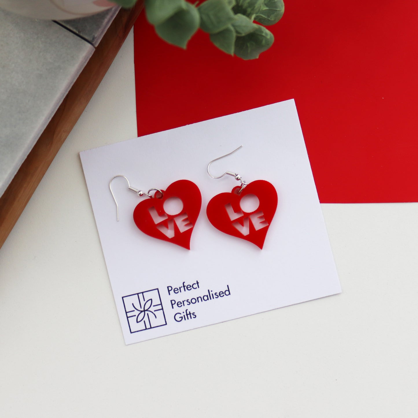 red laser cut acrylic heart earrings with love cut out from the centre