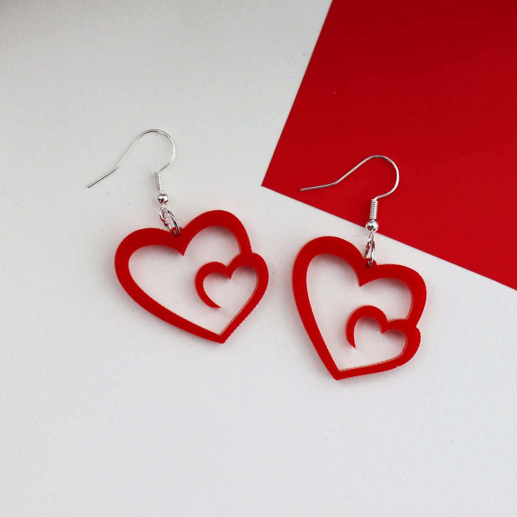 red laser cut acrylic heart swirl earrings which are made on silver plated hypoallergenic hook earring backings