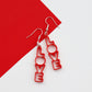 simple but bold red acrylic LOVE earrings which are shown on a dymanic red and white background