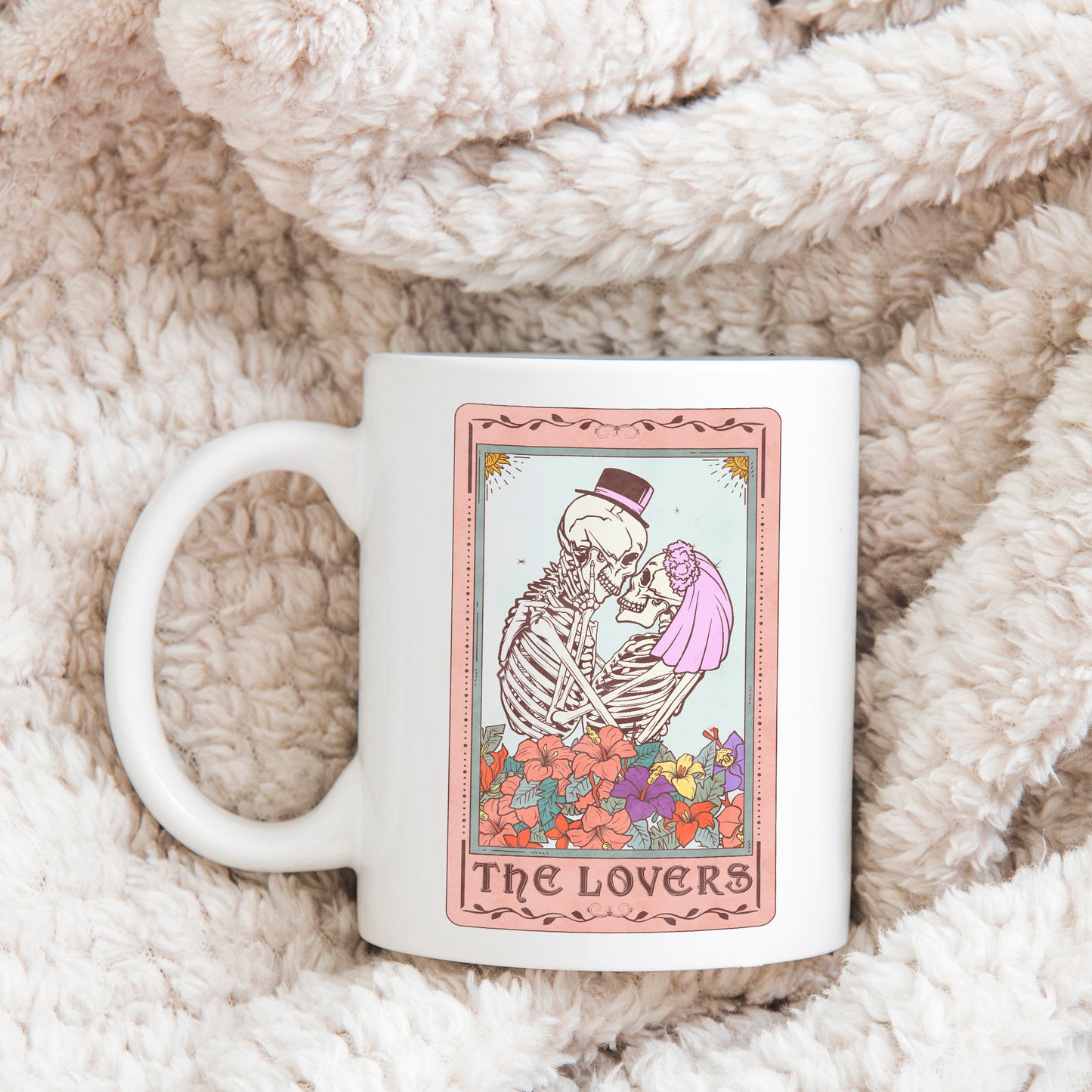 white mug printed with the lovers tarot card showing a skeleton with a top hat and a skeleton with a veil