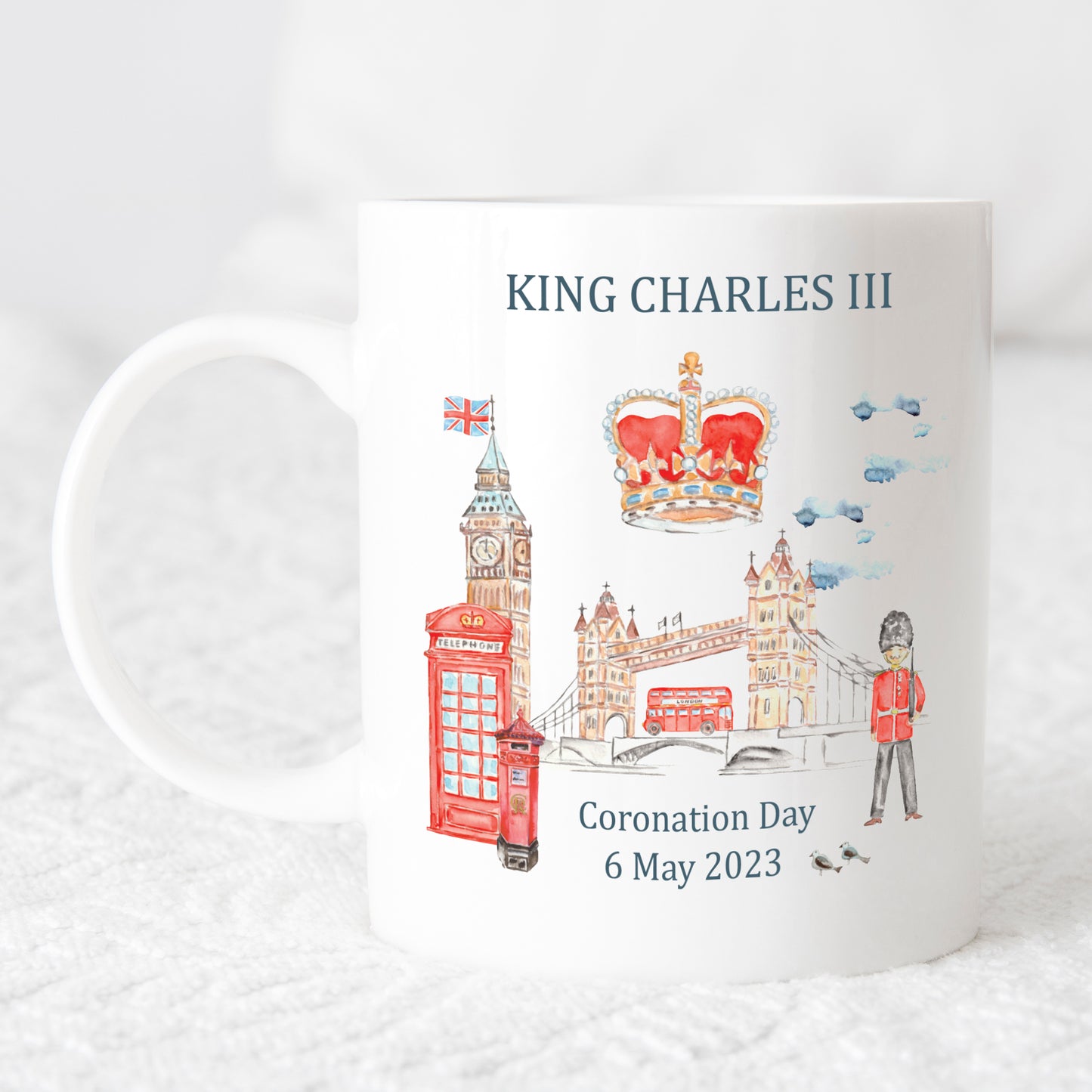 white mug printed with watercolour images of London and the words King Charles III coronation 6 May 2023