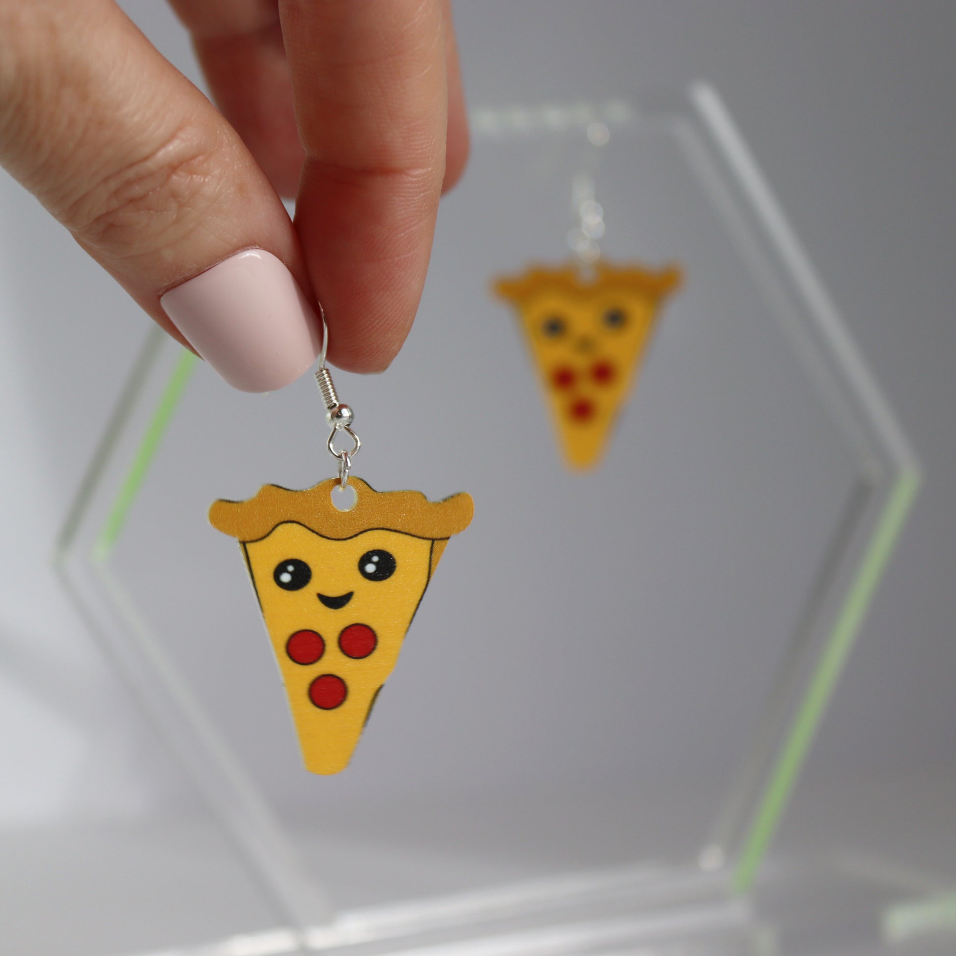 you have a pizza my heart earrings acrylic printed heart earrings shown hanging from a hand